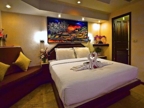 卡伦海滩天堂客栈的一间卧室配有一张大床,上面有粉红色的带子