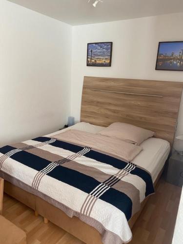 杜塞尔多夫里昂公寓的一间卧室配有一张带木制床头板的床