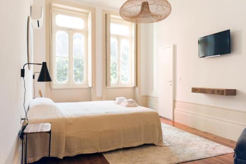 波尔图Alameda Suites - River Guest House的一间卧室配有一张床和一台平面电视