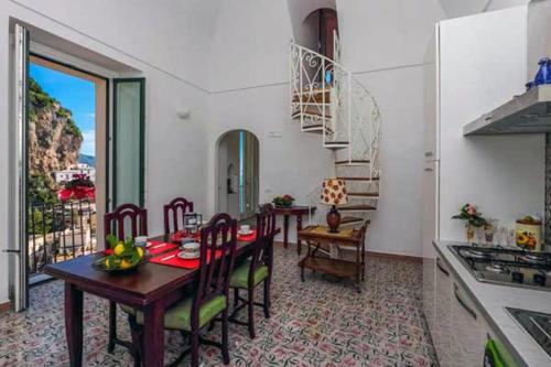 阿特拉尼Amalfi Antica的厨房以及带桌椅的用餐室。