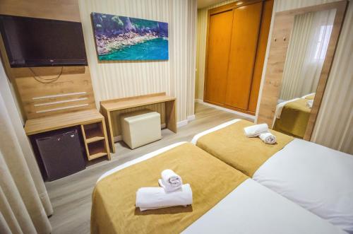 马拉加索利玛酒店的酒店客房设有两张床和一台平面电视。