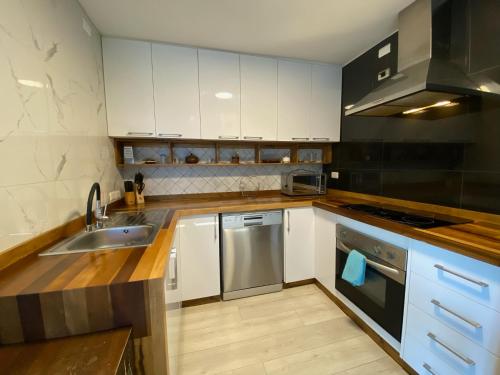 延基韦Linda y cómoda casa individual的厨房配有白色橱柜和不锈钢洗碗机。