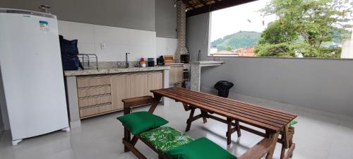 帕拉蒂Casa do Sérgio, Lindo loft-02 moderno e confortável.的厨房配有木桌和两把椅子