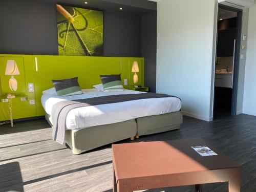勒韦尔努瓦Golf Hotel Colvert - Room Service Disponible的一间卧室设有一张大床和绿色的墙壁