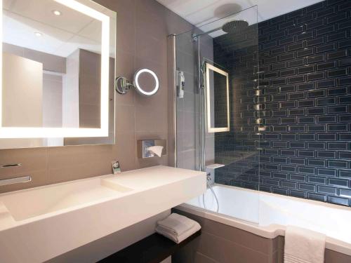 塞纳河畔伊夫里巴黎塞纳河畔伊夫里美居酒店的一间带水槽和镜子的浴室