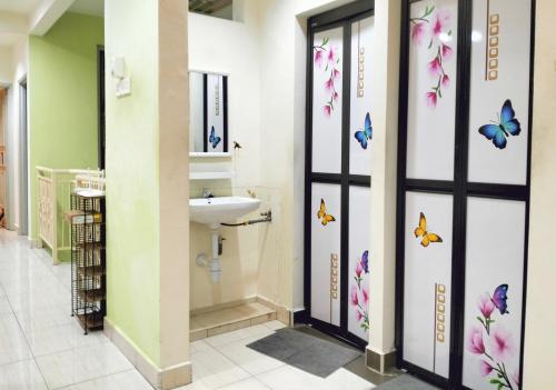 新山JB Austin Perdana Homestay@Simple Comfy For 11pax的墙上设有带水槽和蝴蝶的浴室