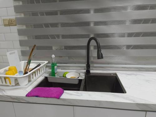 哥打巴鲁LUXURY Modern House Kubang Kerian UNIFI 4 Bedrooms的厨房水槽,配有紫色的布袋和水槽
