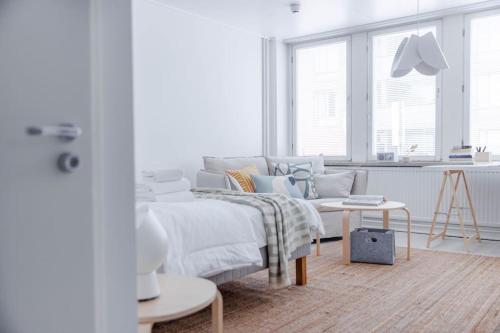 赫尔辛基Studio for a business traveler的白色卧室配有床和桌子
