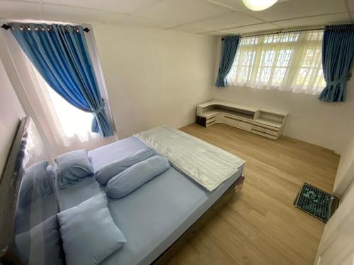 不拉士打宜Villa Berastagi Indah A17 - TEBU MANIS的一间卧室配有大床和蓝色窗帘