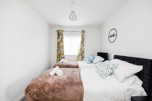 巴尔金Newly refurbished charming 3-Bed House in Barking的一间卧室设有两张床和窗户。