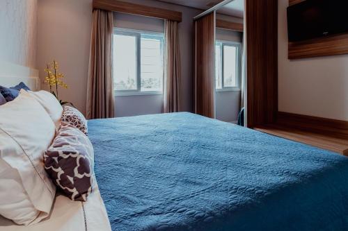 奥兰布拉Bloom Guesthouse的一间卧室配有一张带蓝色毯子的床