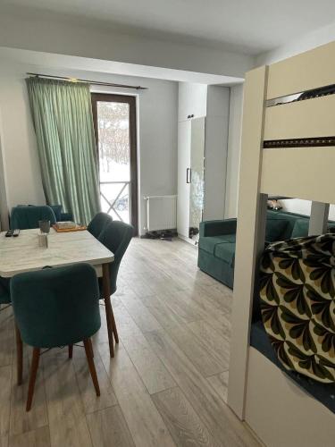 巴库里阿尼Bakuriani mix appartment的一间带桌椅的客厅和一间卧室