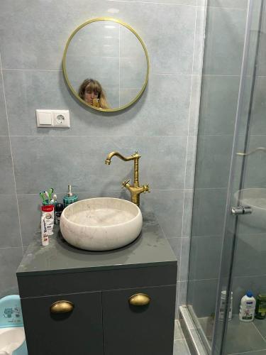 巴库里阿尼Bakuriani mix appartment的浴室设有水槽,镜子里有一个女人