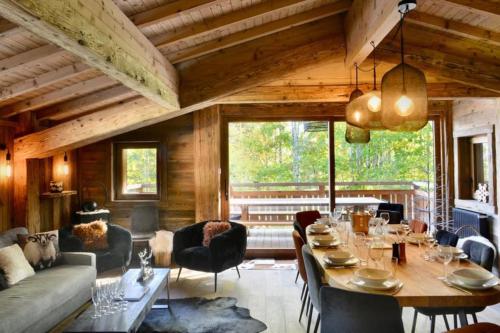 孔布卢Chalet de luxe sur les pistes - 5 chambres的客厅配有桌椅和大窗户