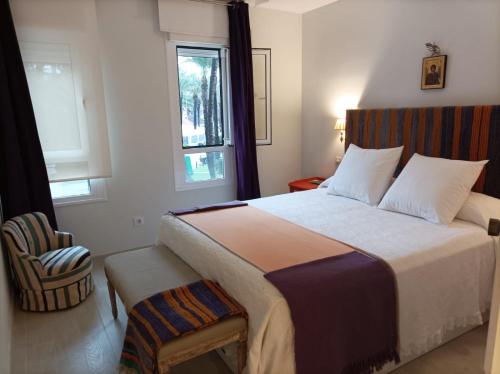 索托格兰德Sotogrande Paseo del Rio的一间卧室配有一张带窗户和椅子的床