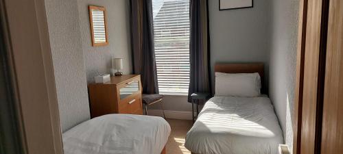锡福斯Mersey View, Two Bedroom Apartment, Liverpool的一间小卧室,配有两张床和窗户