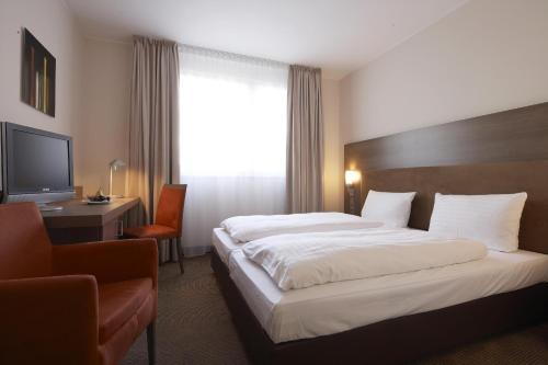 埃森伊森城际酒店的酒店客房设有一张大床和一台电视。