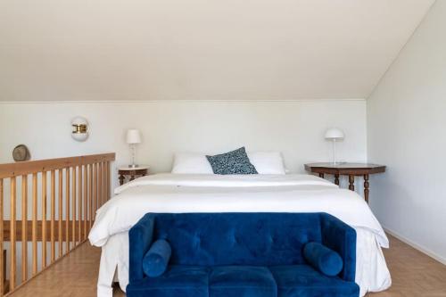 埃克奈斯In the old city of Tammisaari by the shore的卧室内的一张大床和蓝色的沙发