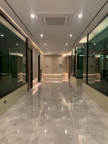 曼谷Thana Wisut Hotel - SHA Plus的建筑中一个空洞的走廊,有玻璃墙