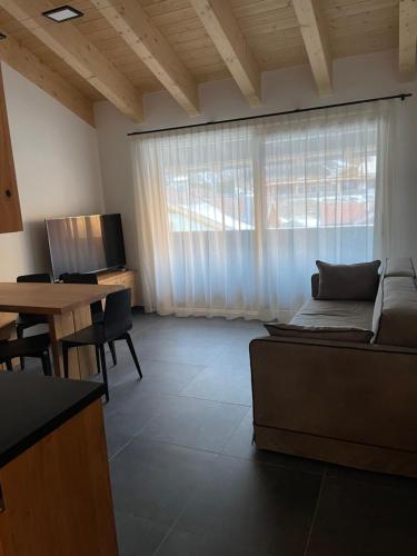 迪马罗Dolomia Apartments & Spa的客厅配有沙发和桌子