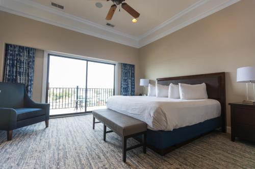 奥沙克湖卡姆登湖度假酒店的一间卧室配有一张床、一把椅子和一个大窗户