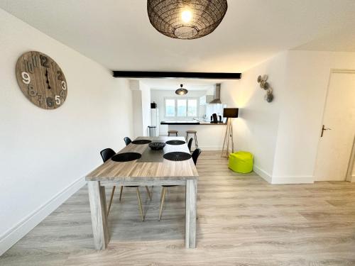 普洛埃默Appartement T3 cosy – Entre bourg et plages的一间设有桌子和墙上时钟的餐厅
