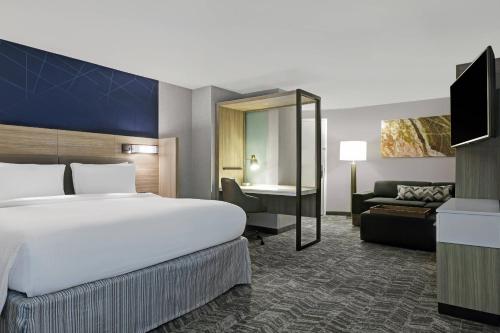 棕榈荒漠SpringHill Suites by Marriott Palm Desert的酒店客房设有一张大床和一张沙发。