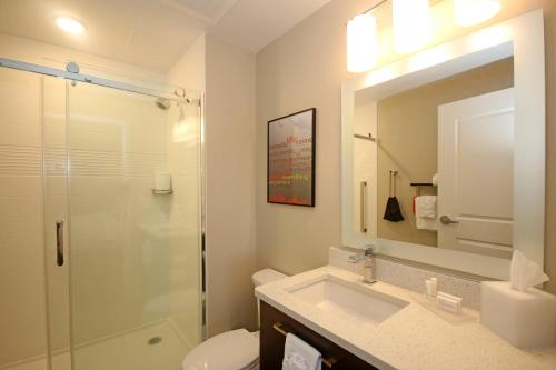 查尔斯顿TownePlace Suites by Marriott Charleston-North Charleston的带淋浴、盥洗盆和镜子的浴室