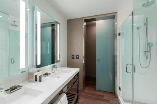 波士顿波士顿市中心万豪AC酒店的一间带两个水槽和玻璃淋浴间的浴室