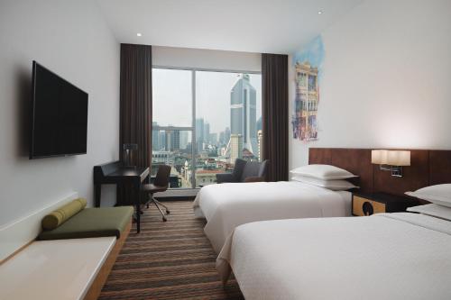 吉隆坡Four Points by Sheraton Kuala Lumpur, Chinatown的酒店客房设有两张床和窗户。