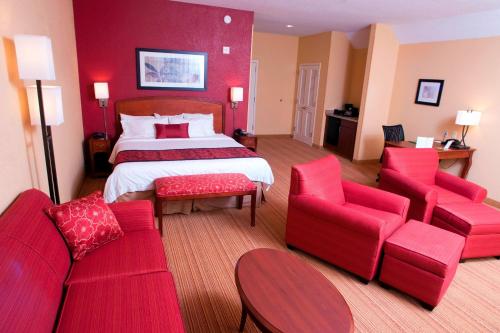 米德尔堡米德尔伯里万怡酒店的酒店客房配有一张床和红色家具