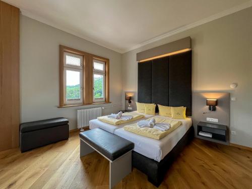 艾森纳赫翰斯海尼斯汀酒店的一间卧室配有一张大床和黑色床头板