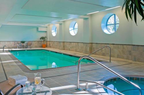 伯灵顿伯灵顿港万怡酒店的一座大型游泳池,设有两扇窗户,位于大楼内