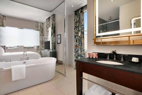 亚特兰大印迹珍品格伦酒店的带浴缸、水槽和镜子的浴室