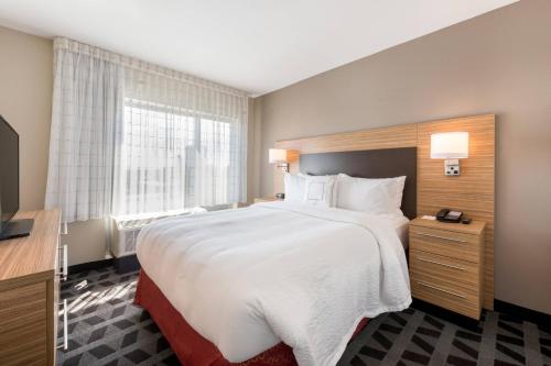 格林斯伯勒TownePlace Suites by Marriott Greensboro Coliseum Area的一间设有大床和窗户的酒店客房