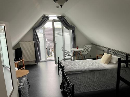 埃尔姆斯霍恩Gästehaus Vigliarolo的一间卧室设有两张床、一个窗口和一张桌子