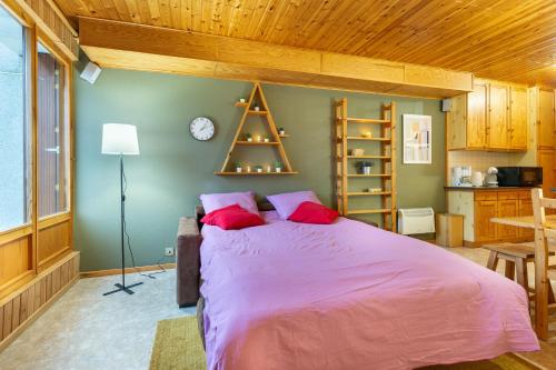 拉布雷斯Le Petit Sapin的一间卧室配有一张带红色枕头的大床