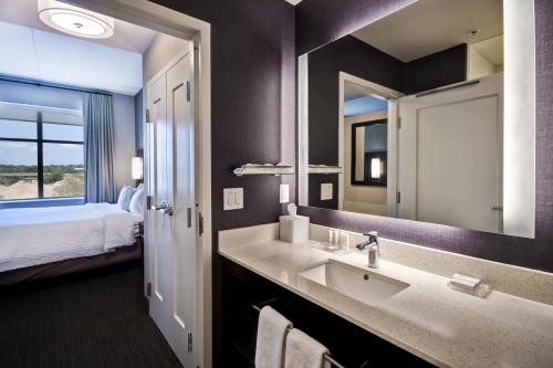 梅森Residence Inn by Marriott Cincinnati Northeast/Mason的一间带水槽和镜子的浴室以及一张床
