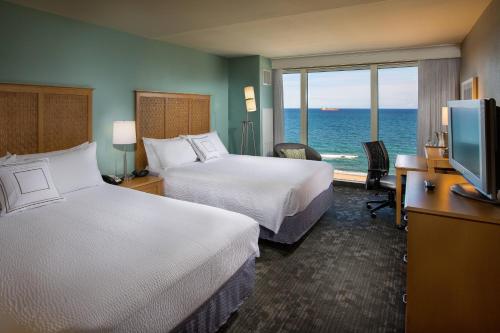 劳德代尔堡Courtyard by Marriott Fort Lauderdale Beach的酒店客房设有两张床,享有海景。