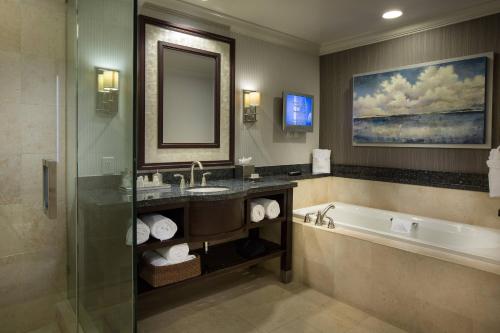 劳德代尔堡Courtyard by Marriott Fort Lauderdale Beach的带浴缸、水槽和镜子的浴室
