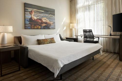 基洼岛安德尔旅馆 的酒店客房设有一张床,墙上挂有绘画作品