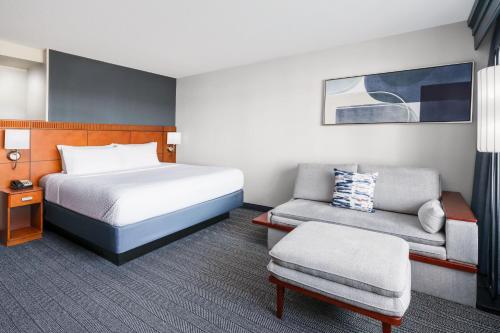 法明顿哈特福德顿万怡酒店的配有一张床和一把椅子的酒店客房
