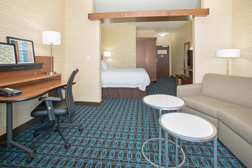 伯灵顿Fairfield Inn & Suites by Marriott Burlington的酒店客房设有沙发、书桌和床。