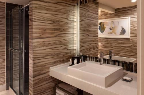 达拉姆Marriott Raleigh Durham Research Triangle Park的浴室配有白色水槽和淋浴。