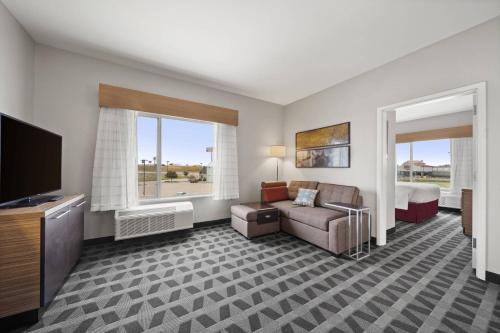 韦科TownePlace Suites Waco Northeast的酒店客房设有沙发、床和电视。