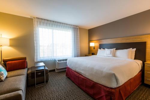 比弗顿TownePlace Suites by Marriott Portland Beaverton的酒店客房设有一张大床和一张沙发。