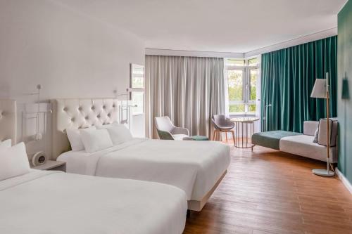 慕尼黑慕尼黑万豪酒店的酒店客房带两张床和一张桌子以及椅子。