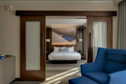 肖特帕姆短泵里士满万豪酒店的一间卧室,卧室内配有一张床和一张蓝色椅子