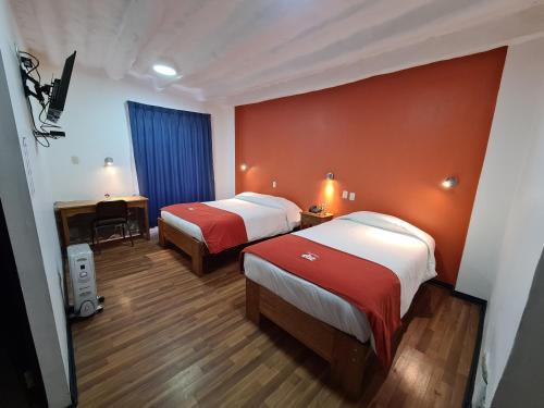 库斯科卡萨坎佩斯纳酒店的酒店客房配有两张床和一张书桌