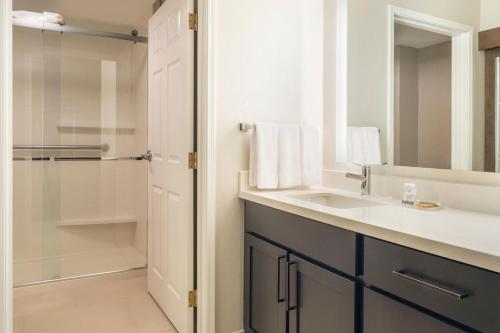 盐湖城盐湖城机场Residence Inn酒店的一间带水槽和淋浴的浴室